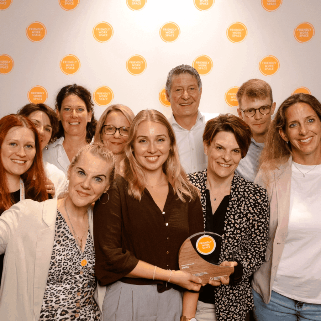 Team von SWICA posiert mit Auszeichnung bei einem Event