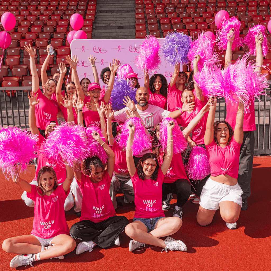 Gruppe in pinken Outfits feiert gemeinsam den Pink Ribbon Charity Walk