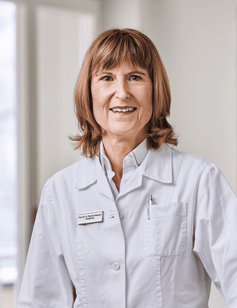 Donna in piedi con camice bianco da medico: Dott.ssa Ruth Fleisch Silvestri